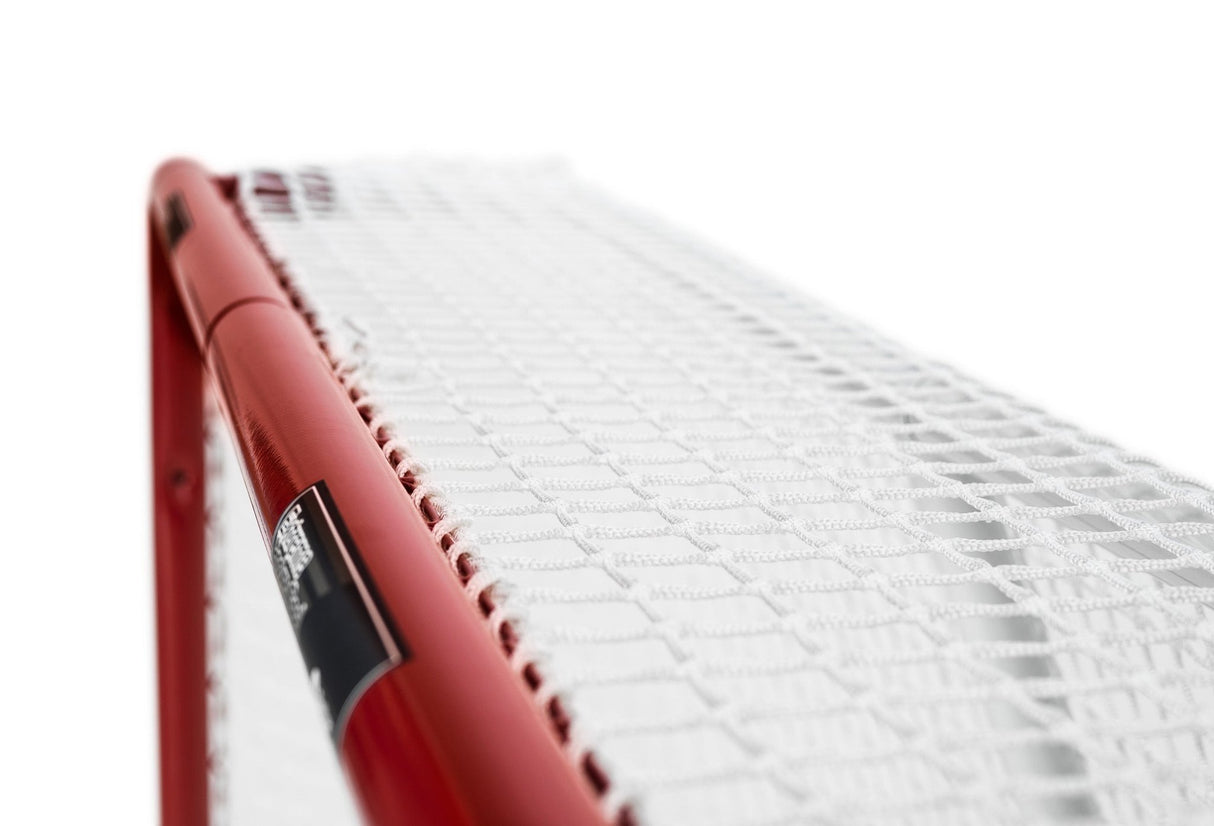 Detalj av Extreme Hockey Goal Pro Steel med röd ram och nät, hållbart designat för spel med hög hastighet.