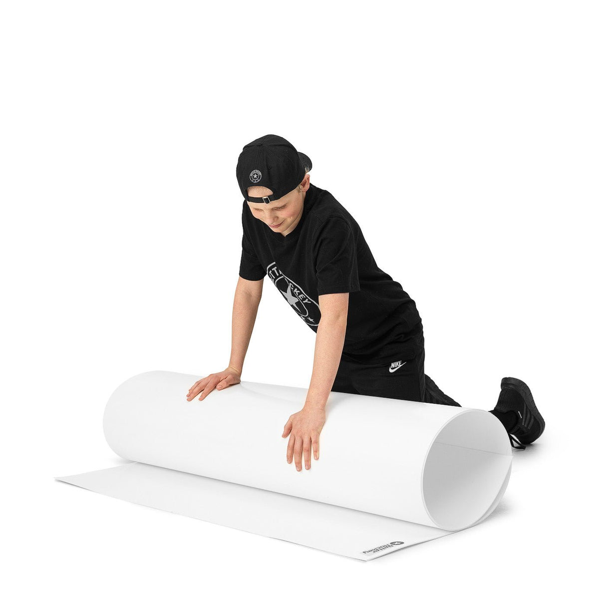 Ungdom rullar ut en skottplatta för hockeyträning, perfekt för att förbättra skjutskillnader.